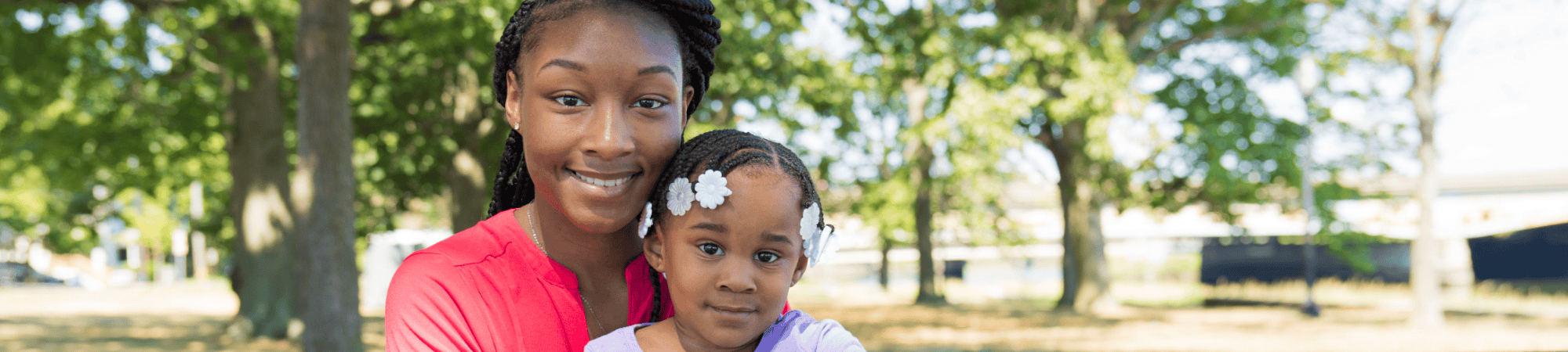 mom holding toddler daughter smiling